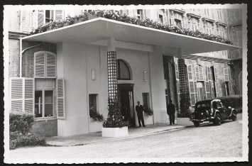 A l'entrée, des voituriers et une voiture de collection indiquent le caractère luxueux de cet hôtel à la clientèle aisée.