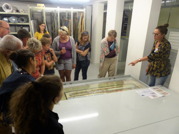 Photographie d'un groupe de visite devant la réserve conservant les documents précieux aux Archives du Calvados.