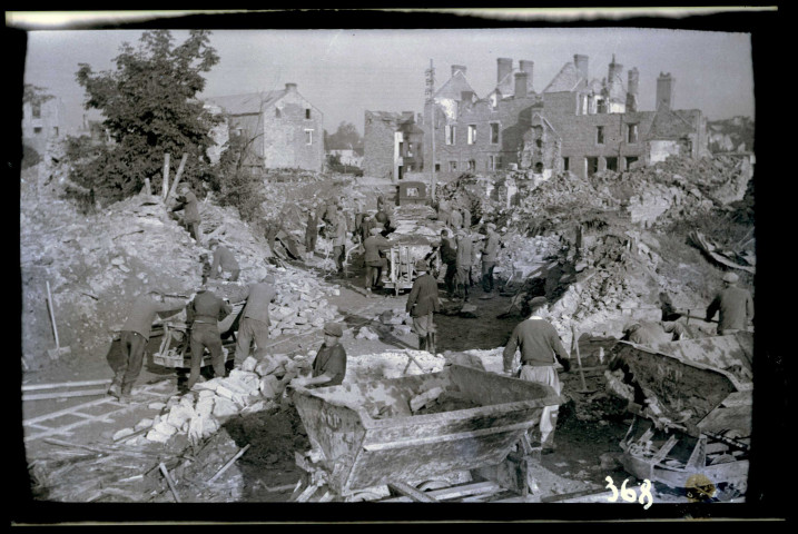 Chantiers de reconstruction de Condé-sur-Noireau, ruines, baraquements provisoires en forme de tonneaux, ouvriers (photos n°315 à 330 ; 342 à 344)