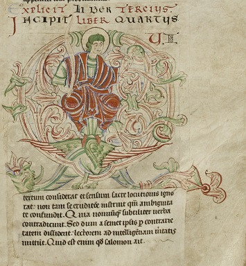 Une enluminure prend place au sein du texte avec un personnage auréolé vêtu en rouge.