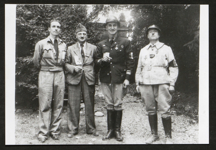 Les quatres hommes sont dans diverses tenues militaires. Léonard Gille est reconnaissable à son casque, son brassard FFI à la Croix de Lorraine et sa grande taille. Il porte ici des bottes et lève un verre de la main droite.