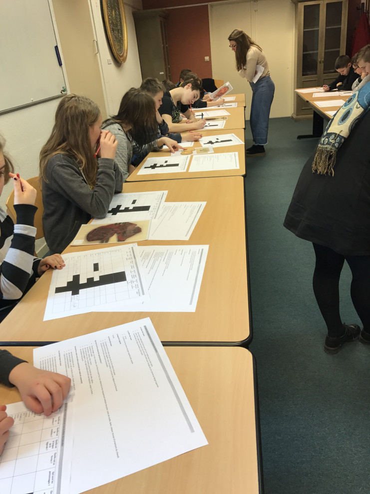 Des élèves en salle de classe des Archives du Calvados étudient des documents.