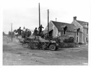 "Contre-offensive à Caen. Le commandant de division debout sur le char, observe le champ de bataille et donne ses ordres" (photo 77)