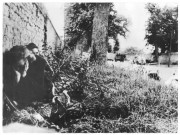 Deux femmes accroupies le long d'un mur (photos 118 et 336)