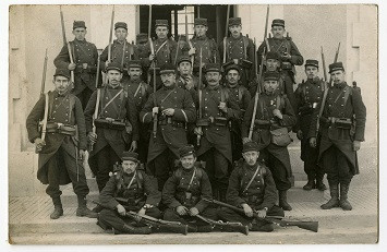 Un groupe de soldats de la Première Guerre mondiale avec leurs fusils pose pour la photographie.