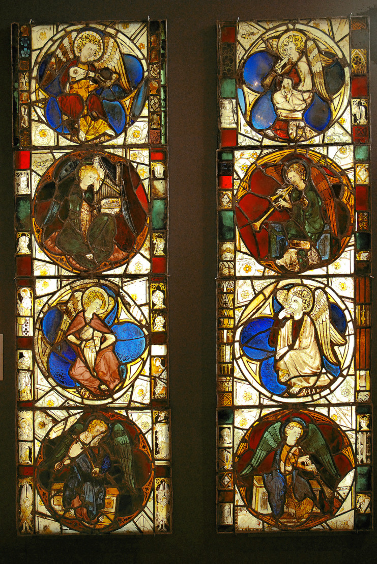 Dans des vitraux multicolores, huit anges sont représentés. Ils jouent tous d'un instrument de musique différent.