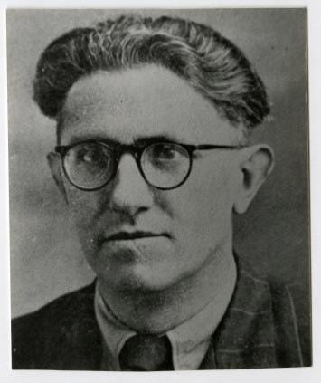 Robert Guédon porte des lunettes rondes.