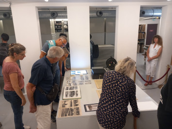 Photographie d'un groupe de visite devant la réserve conservant les documents précieux aux Archives du Calvados.