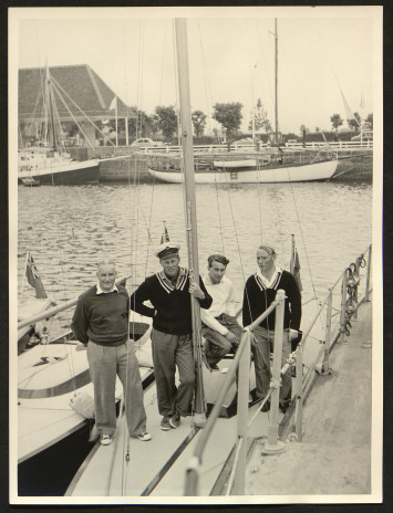 Quatre hommes posent à bord d'un bateau.