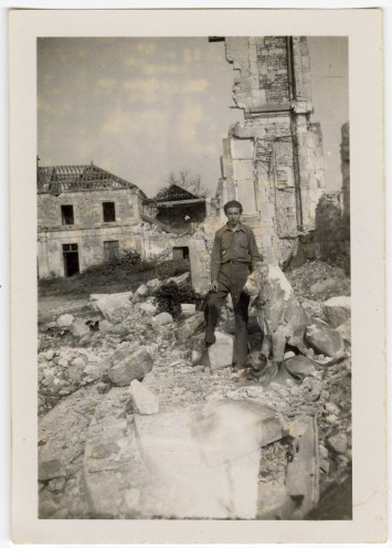 Un homme pose pour la photographie devant le château en ruines qui a été bombardé