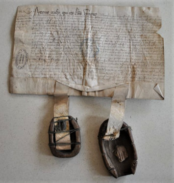 Photographie d'une coque en bois ayant servi à conditionner le sceau en cire appendu à un acte de 1407